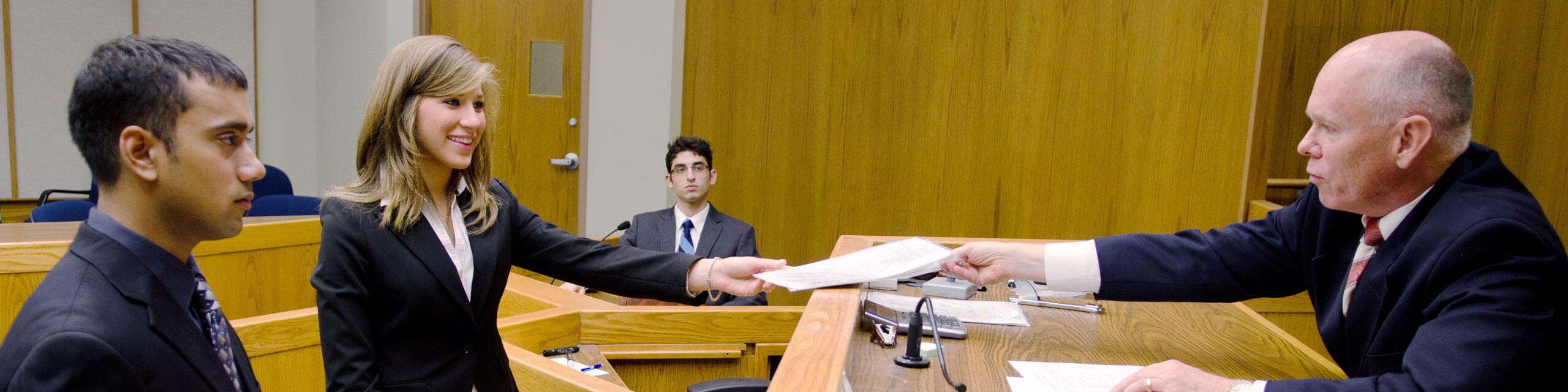 Two lawyers approach the bench in a mock trial.